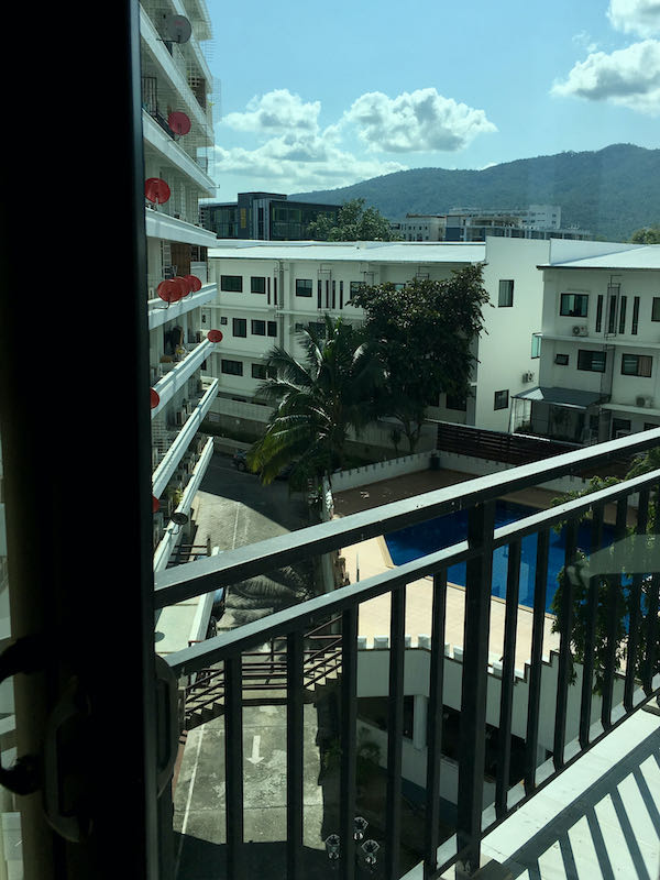Pool and mountain view in apartment block popular with digital nomads in Chiang Mai.
