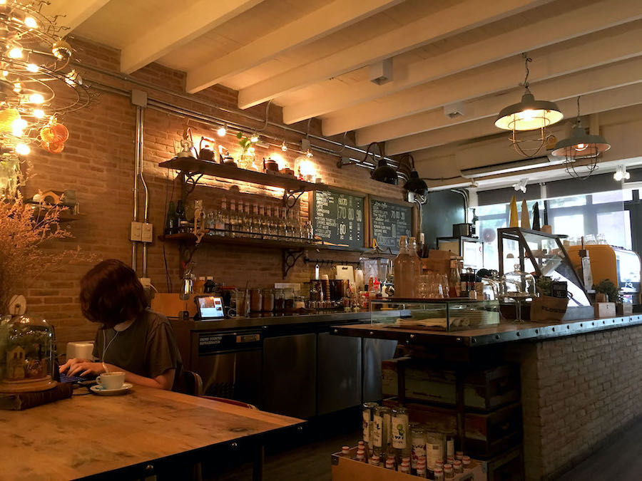 A digital nomad in Chiang Mai works on her laptop at a cafe.