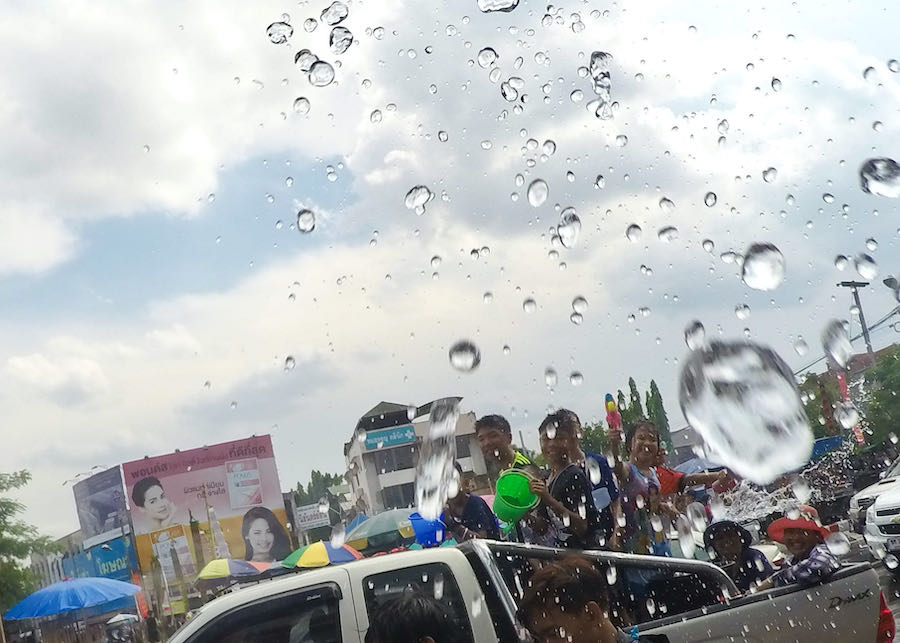 Local kids participate in the Songkran Water Festival from the back of a pickup truck driving around Chiang Mai moat.
