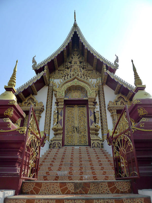 Red and gold entrance to Wat Rajamontean next to Chiang Mai moat.
