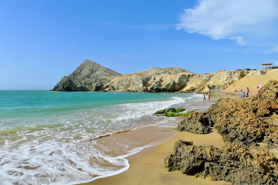 People enjoy the beach and gentle waves on Playa del Pilón de Azucar.