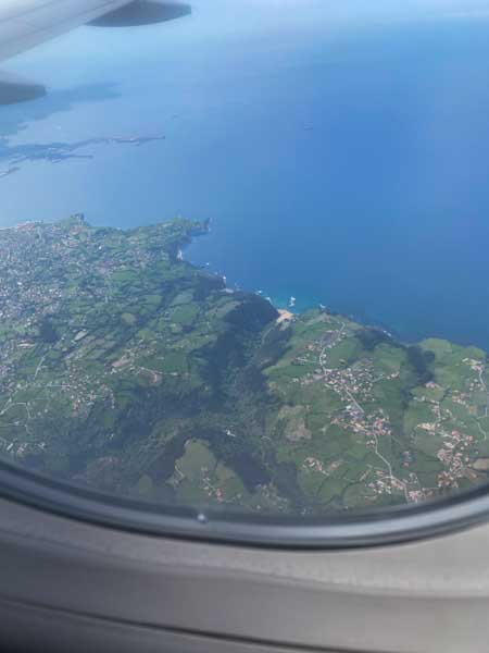 View of green hills and coastline from my plane window approaching Asturias airport in northern Spain.