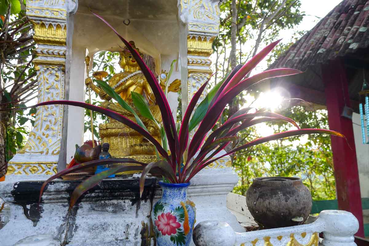 Statue and plants at Chedi Phra That Mae Yen hilltop temple in Pai, Thailand.