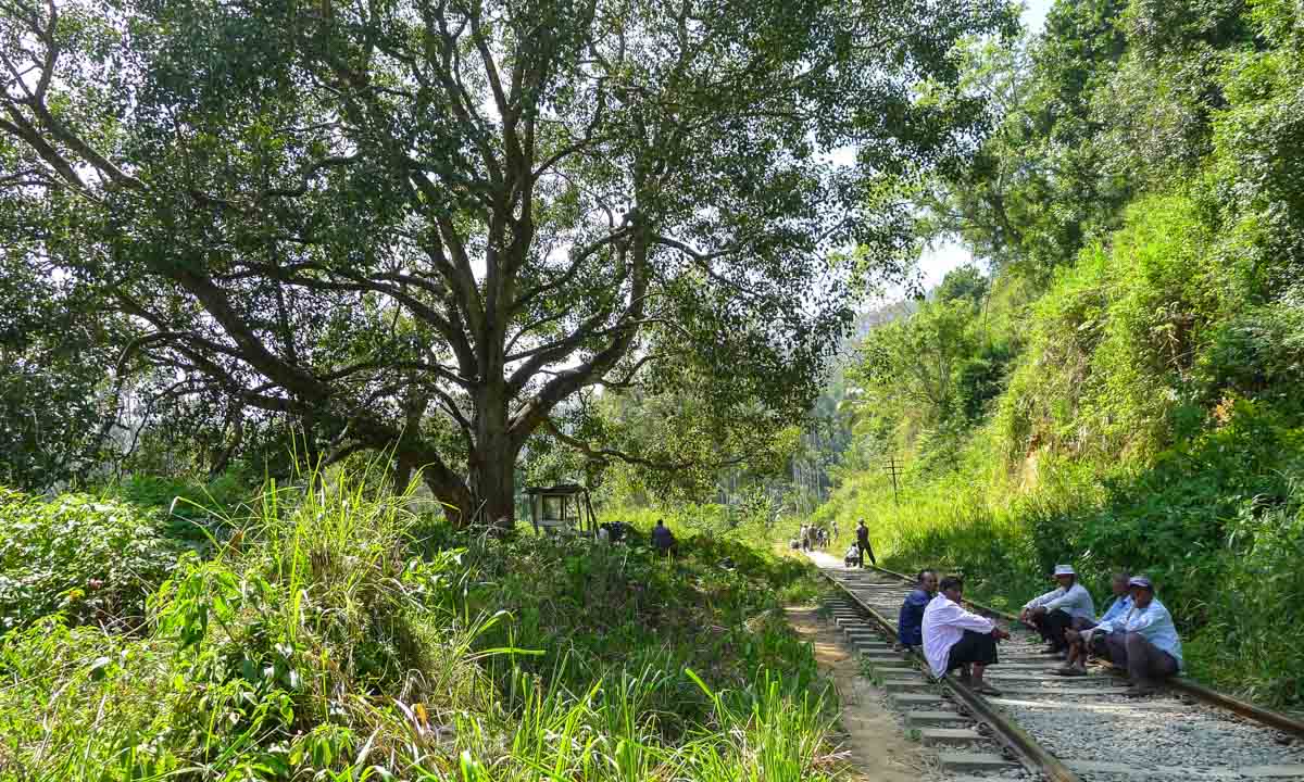 Men sitting on the train tracks on my hike to Ella Rock.