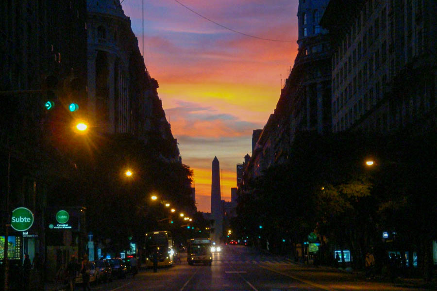 The Buenos Aires Obelisco viewed in between buildings on Diagonal Norte with a spectacular sunset in the background.