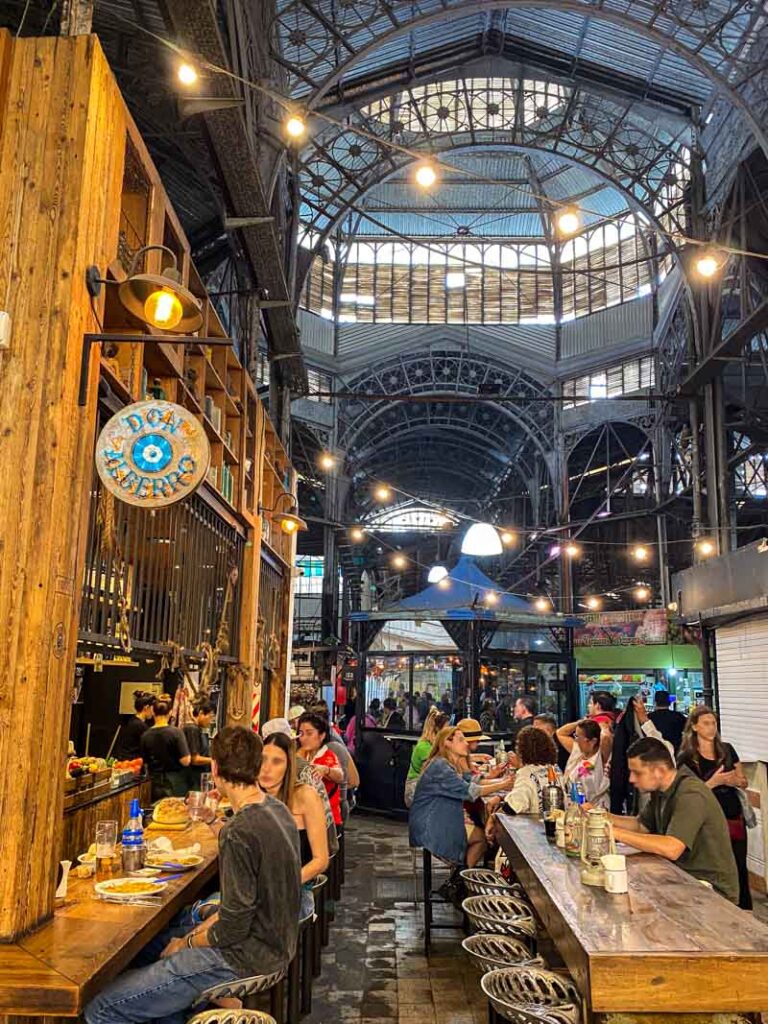 People eat in the busy food hall inside the Mercado de San Telmo.