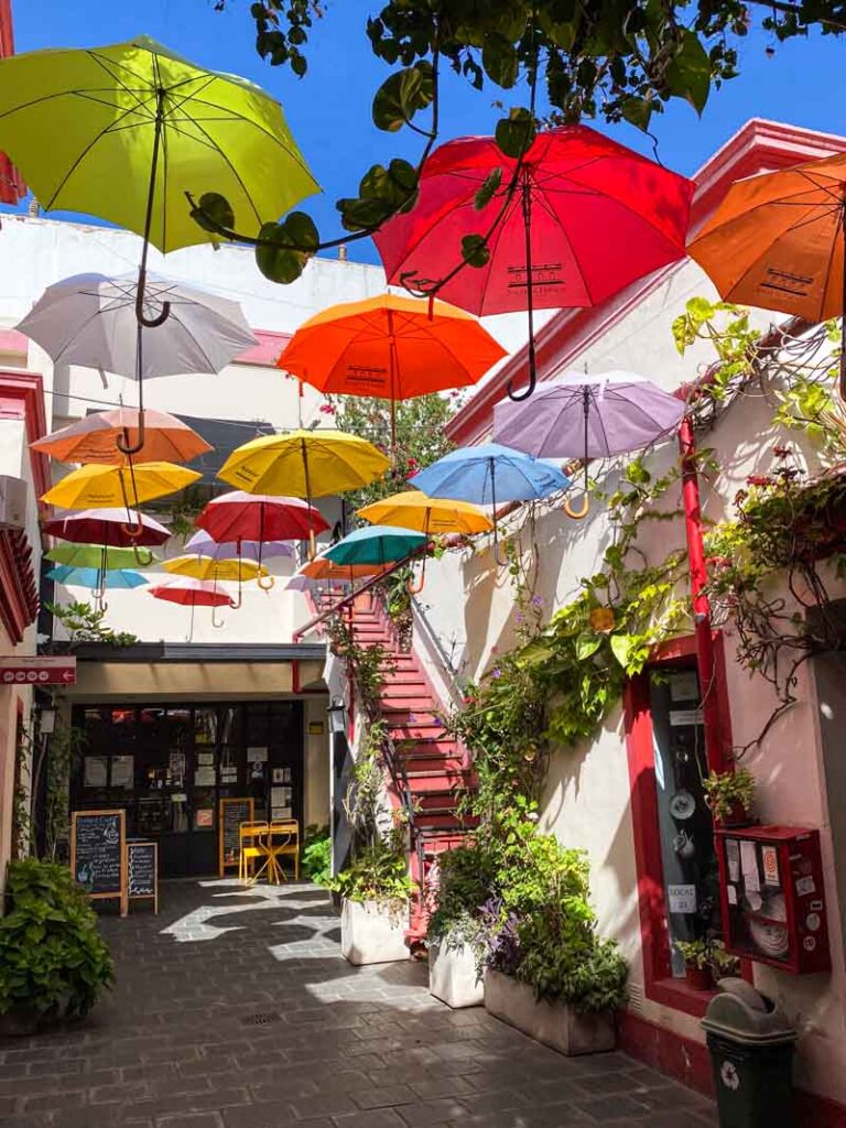 Colorful decorative umbrellas hanging above shops at Galería Solar de French in Buenos Aires.