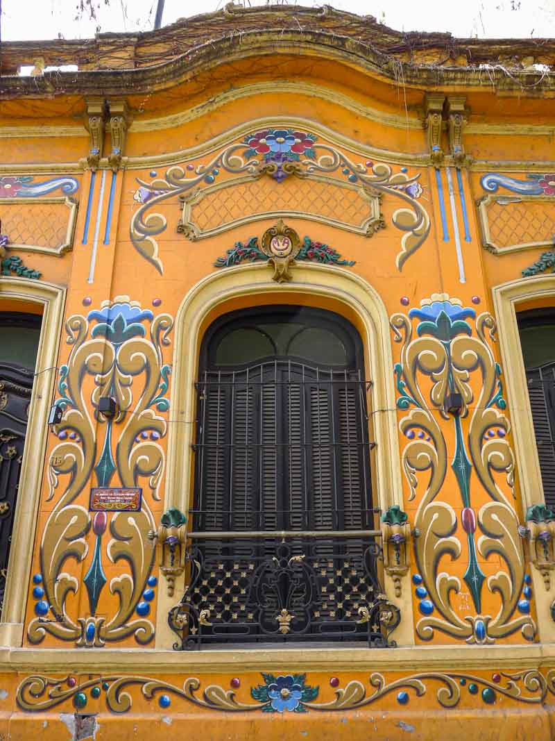 An orange façade decorated with traditional fileteado porteño in Buenos Aires.