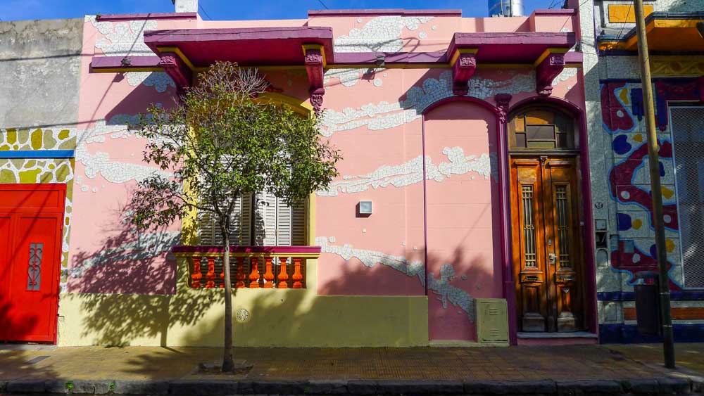 Pink facade with purple moulding and white tiles on Calle Lanín in the Barracas neighborhood of Buenos Aires.