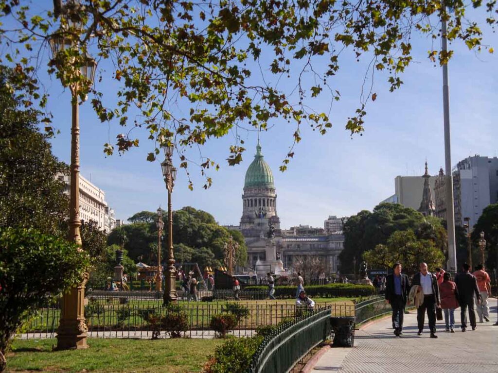 People walk through Plaza del Congreso in Buenos Aires on a sunny fall day.