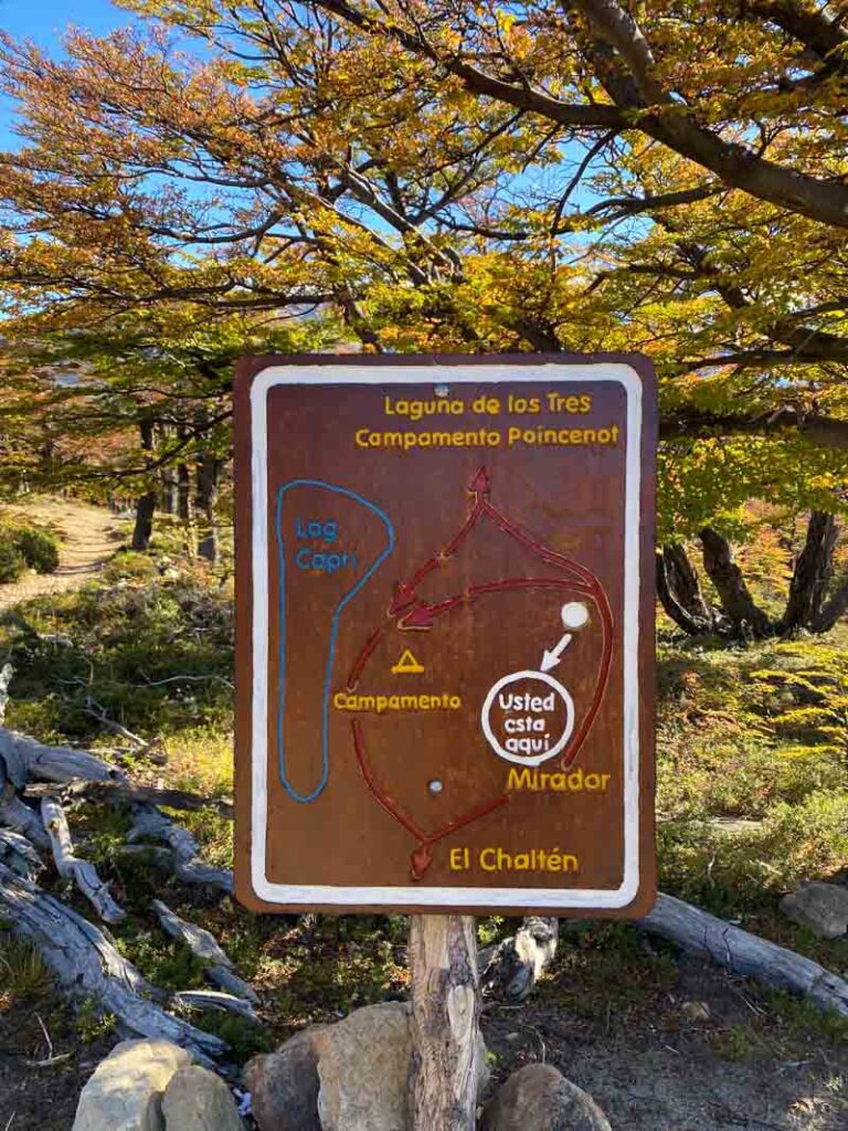 Rough map on a brown sign showing directions to El Chaltén, Campamento Poincenot, Laguna de los Tres, and Laguna Capri.