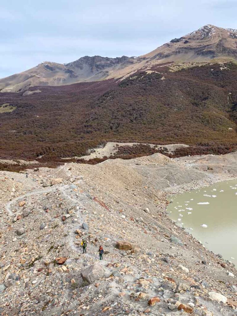 Two hikers descend along a narrow, rocky trail from Mirador Maestri to Laguna Torre.