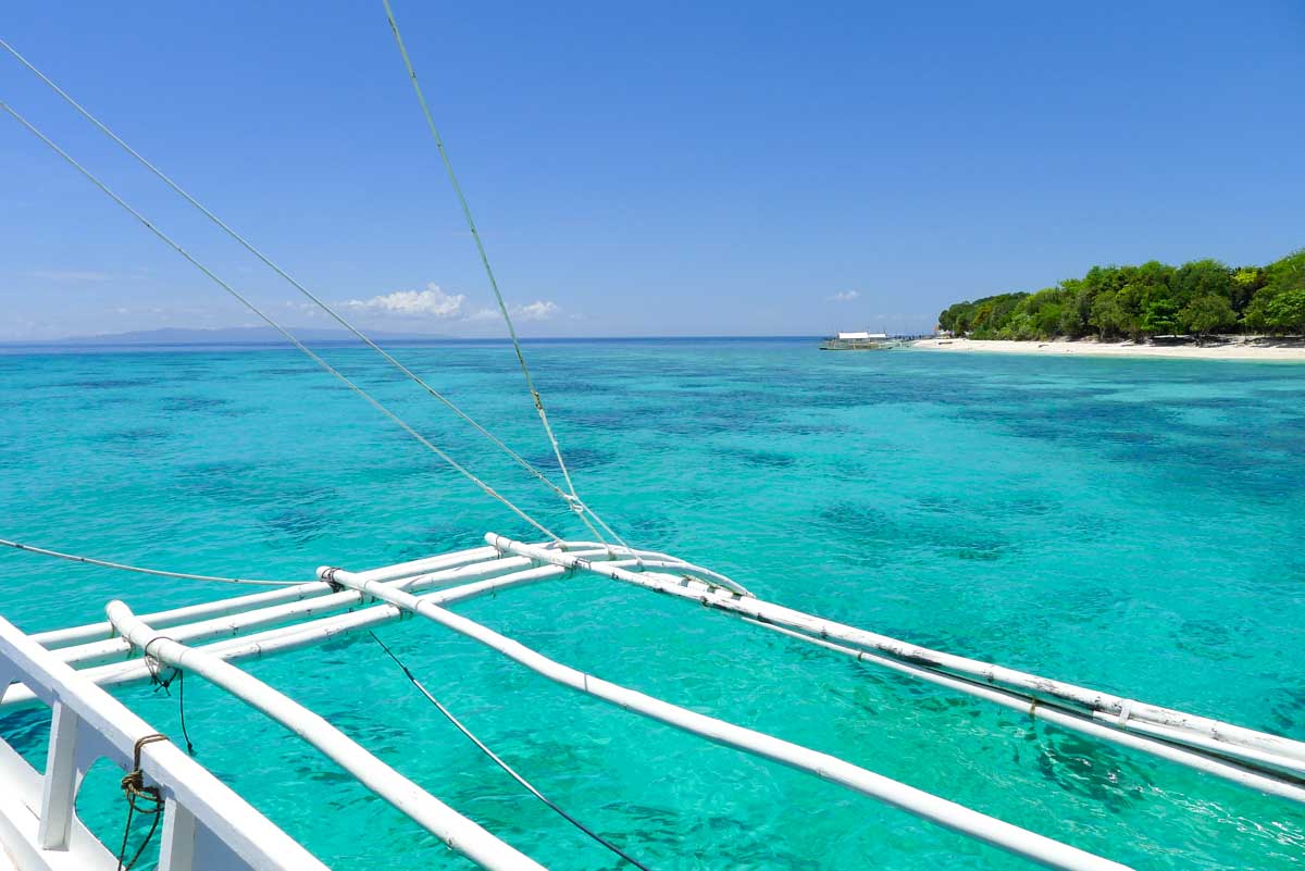 Edge of bangka outrigger boat floating over crystal clear water in between dives on Bohol.