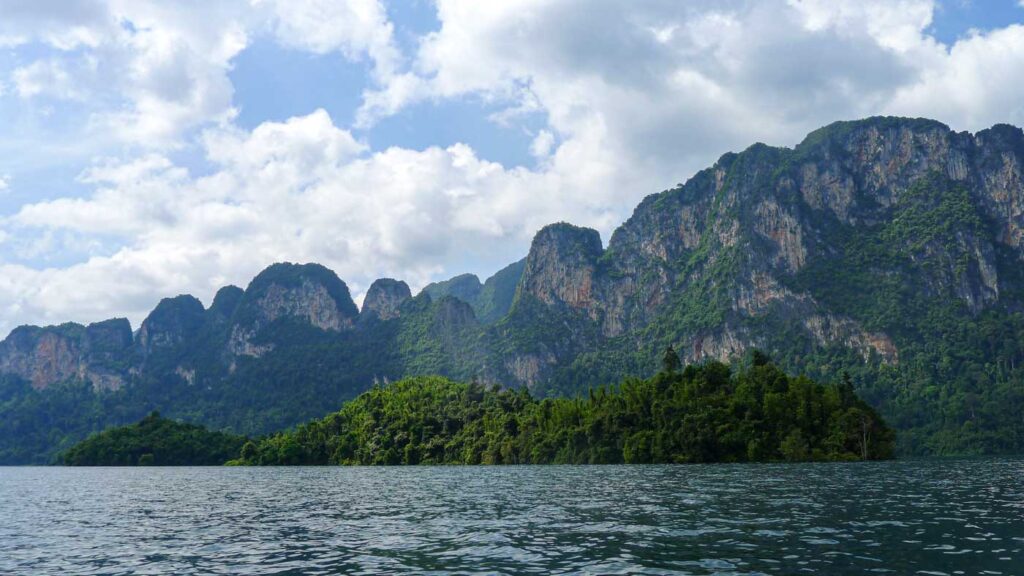 A beautiful wall of limestone cliffs and a jungle island in Khao Sok National Park, Thailand.