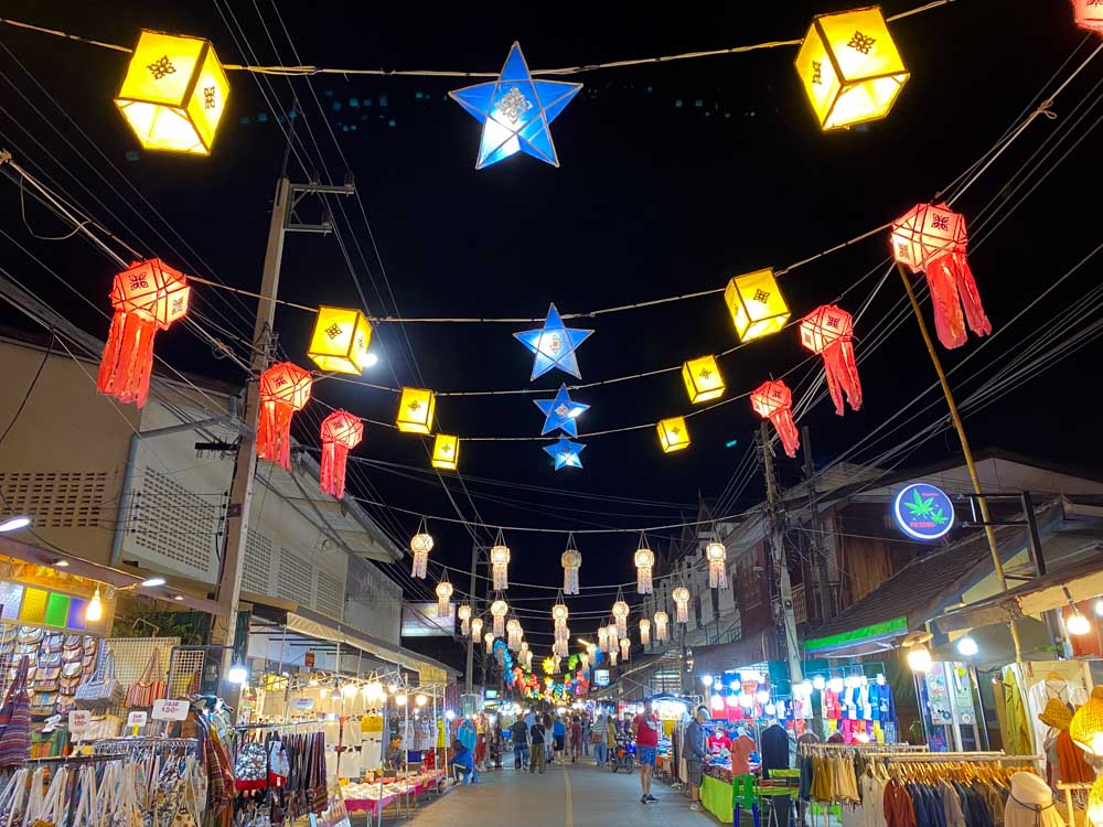Colorful lanterns hang over Pai Walking Street night market stalls selling food and souvenirs.