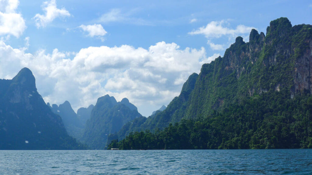 Floating bungalows in Khao Sok National Park appear tiny under the towering limestone cliffs on Cheow Lan Lake.