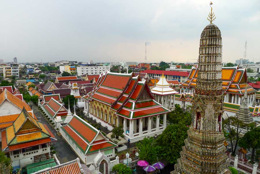 A distinctive spire at Wat Arun (Temple of Dawn) overlooking the temple grounds and Bangkok cityscape.