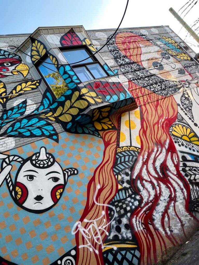 An Ola Volo mural depicting a woman, a bird, and a tea cup just off of Rue Saint-Viateur in Mile End.