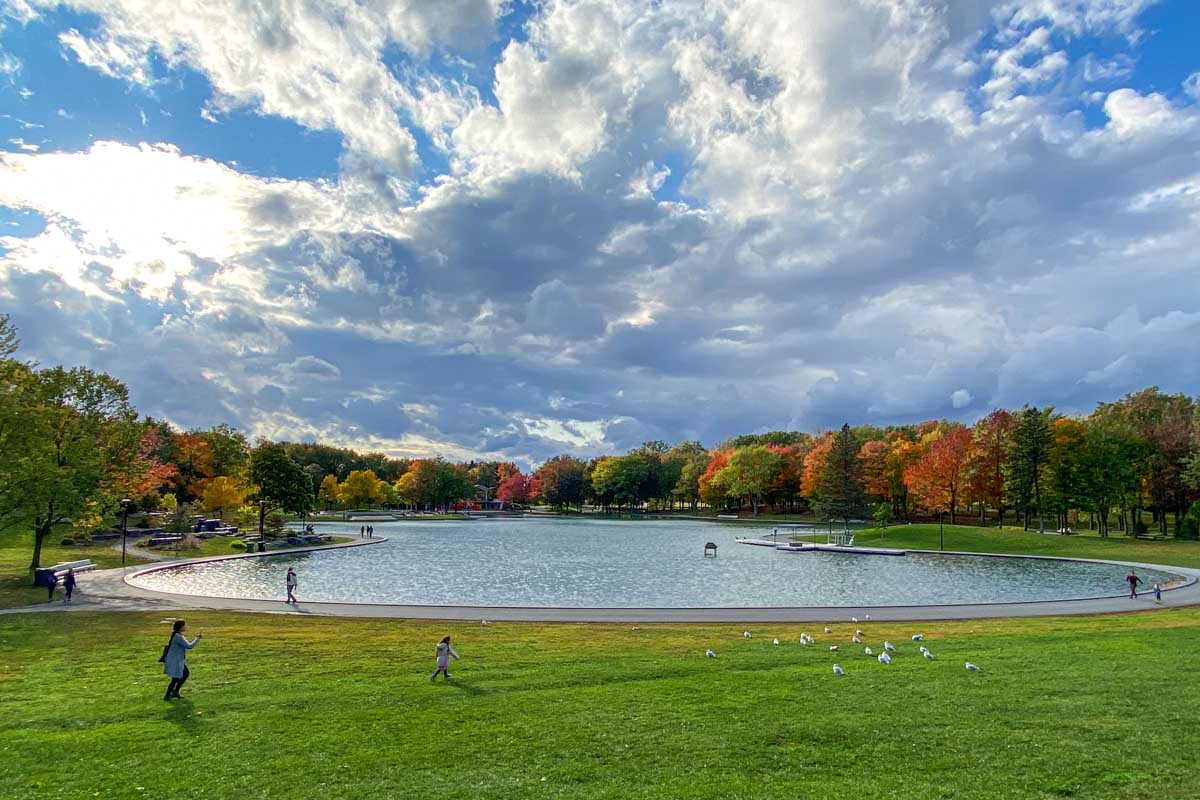 People (and seagulls) enjoy an early fall day at Lac aux Castors surrounded by colorful autumn leaves.