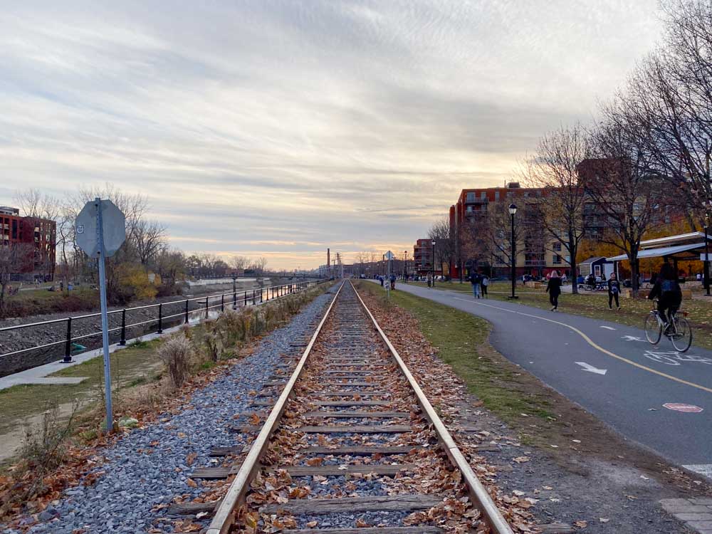 Railroad tracks, a walking path, and a bike path next to the Lachine Canal in Little Burgundy.