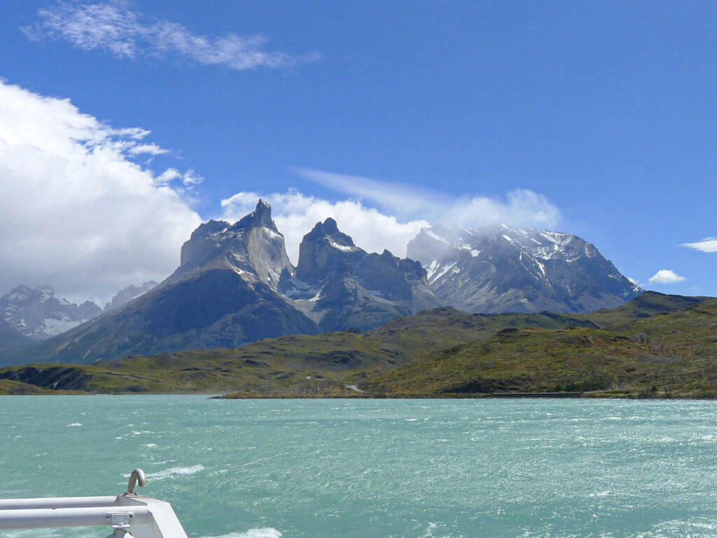 The famous Cuernos del Paine viewed across a light turquoise-colored lake from the Lake Pehoe catamaran.