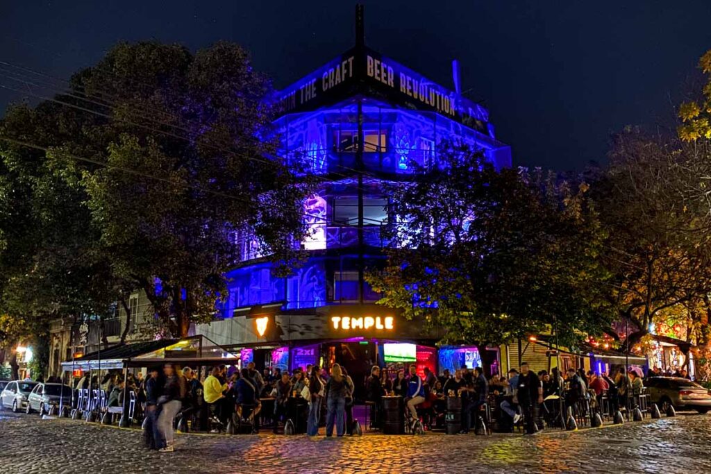 A busy night at Temple Bar on a cobblestone street corner in Palermo, the best neighborhood in Buenos Aires for nightlife.