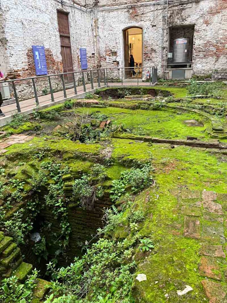 A centuries-old cistern, now covered in green moss, at the historical Illuminated Block in the Monserrat neighborhood.