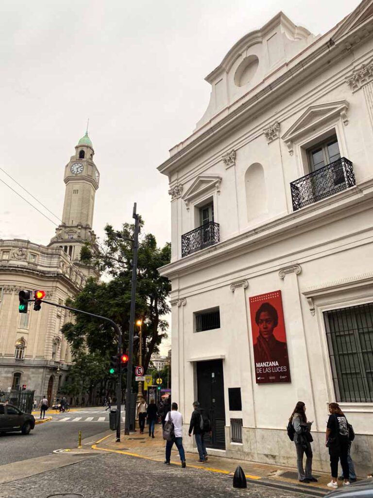A poster of María Remedios del Valle, a Black Argentine independence soldier also known as "la Madre de la Patria," on the wall of a white colonial bulding forming part of the Manzana de las Luces.