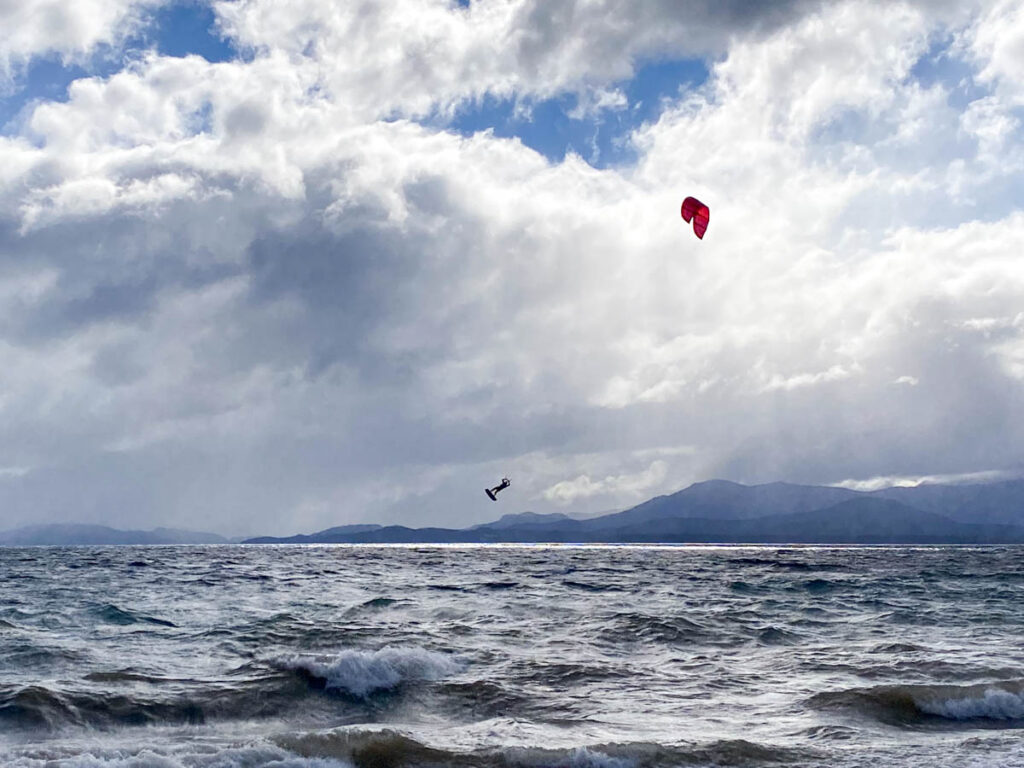 A kitesurfer mid-air over Lago Nahuel Huapi. Adventure sports and water activities are popular things to do in Bariloche.