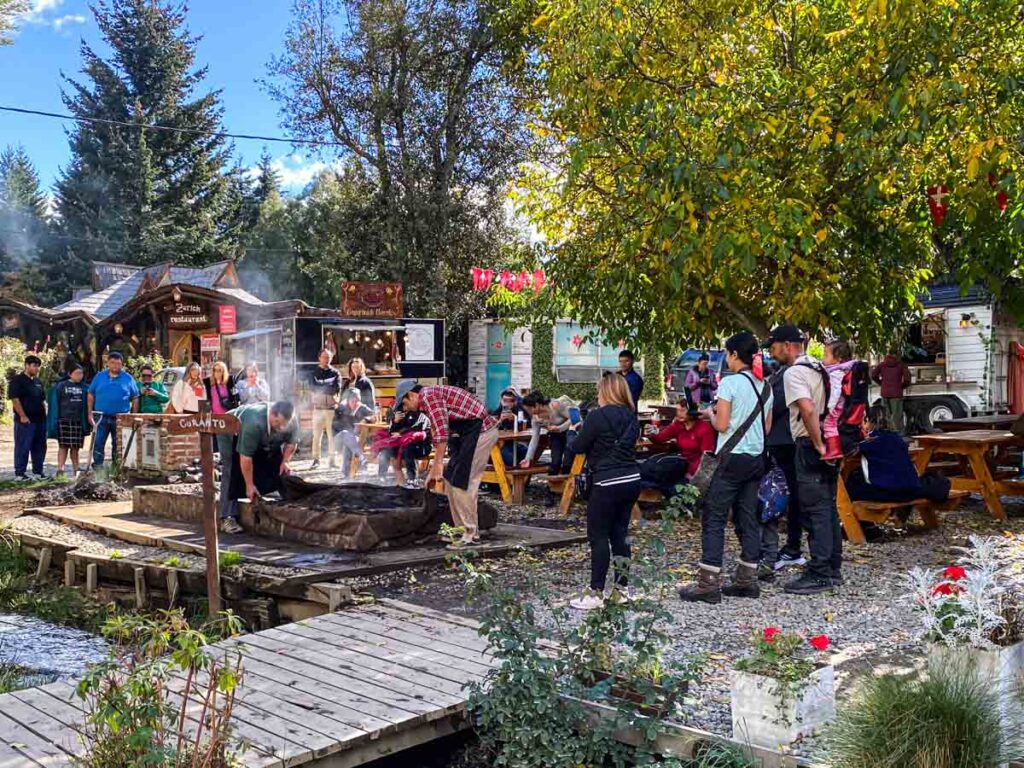 A small crowd observes curanto preparation in Colonia Suiza.